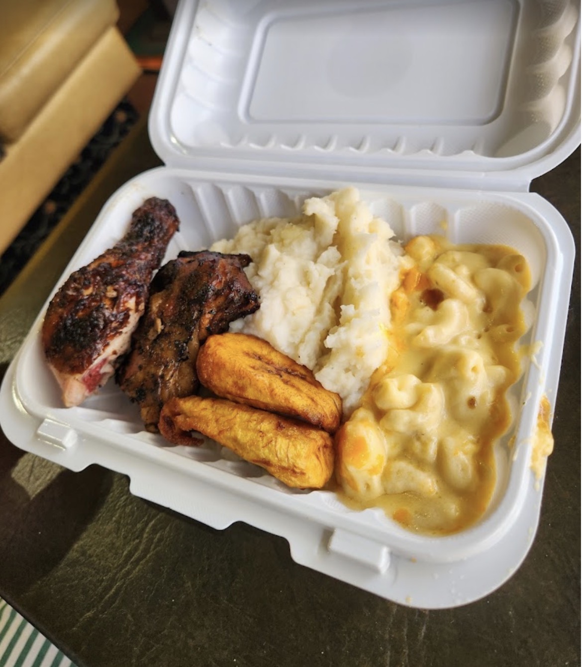 Jerk chicken with mashed potato, fried plantain and mac and cheese